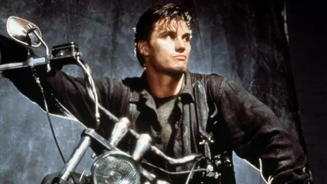 Dolph Lundgren on a black motorcycle as seen in the 1989 film adaptation of The Punisher. 