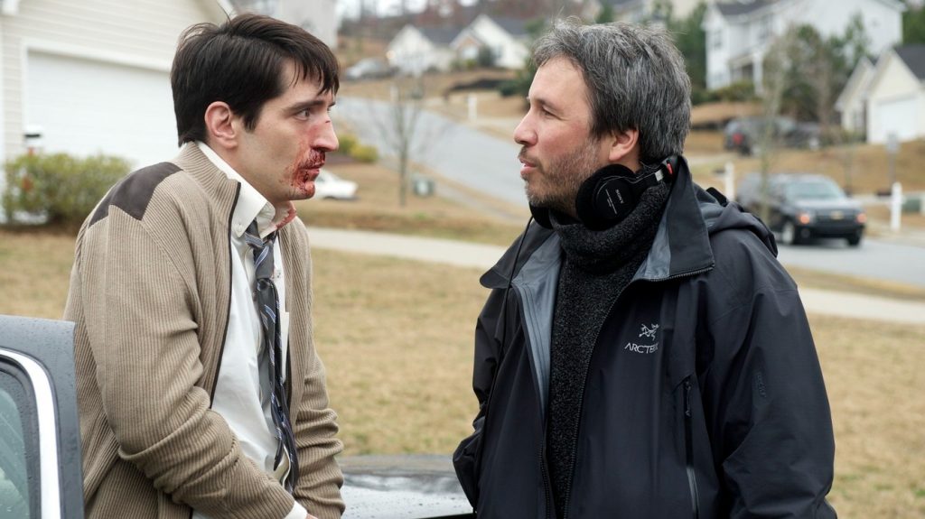 David Dastmalchian with bloody makeup speaks to Denis Villeneuve on the set of Prisoners.