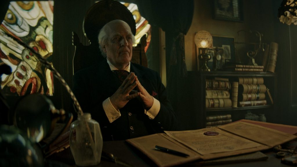 Clancy Brown as Montgomery Dark sits and ponders at his desk in Ryan Spindell's 'The Mortuary Collection'