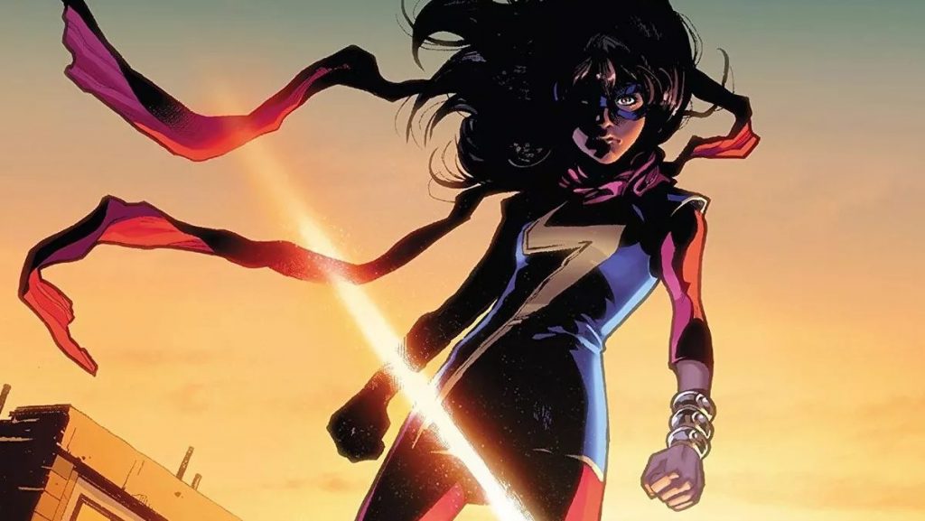Kamala Khan stands on top of a building as her wind blows in the air behind a sunset as seen in Marvel Comics. 