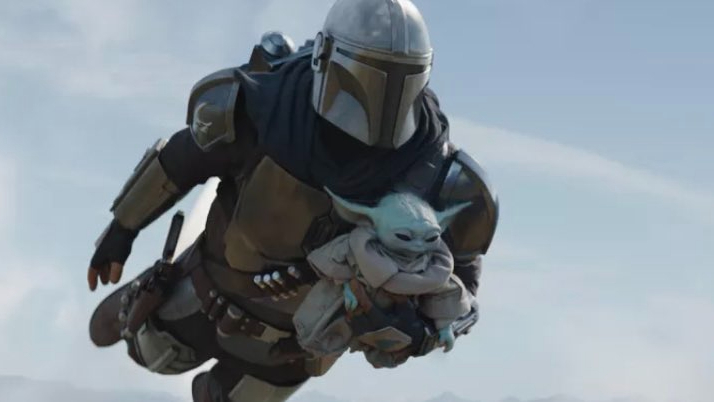 Pedro Pascal's Mando carries Baby Yoda as he flies through the sky with his jet-pack as seen in Chapter 14 of The Mandalorian.