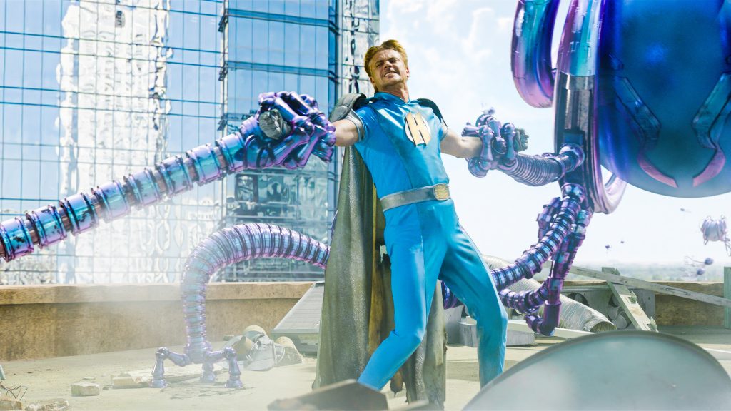 Boyd Holbrook as Miracle Guy fights off an alien spaceship with robotic tentacles as seen in We Can Be Heroes directed by Robert Rodriguez. 