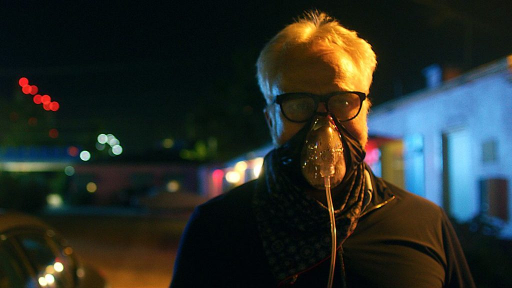 Bradley Whitford wearing a breathing mask to stay safe from the mutated COVID-19 plague as seen in Songbird.