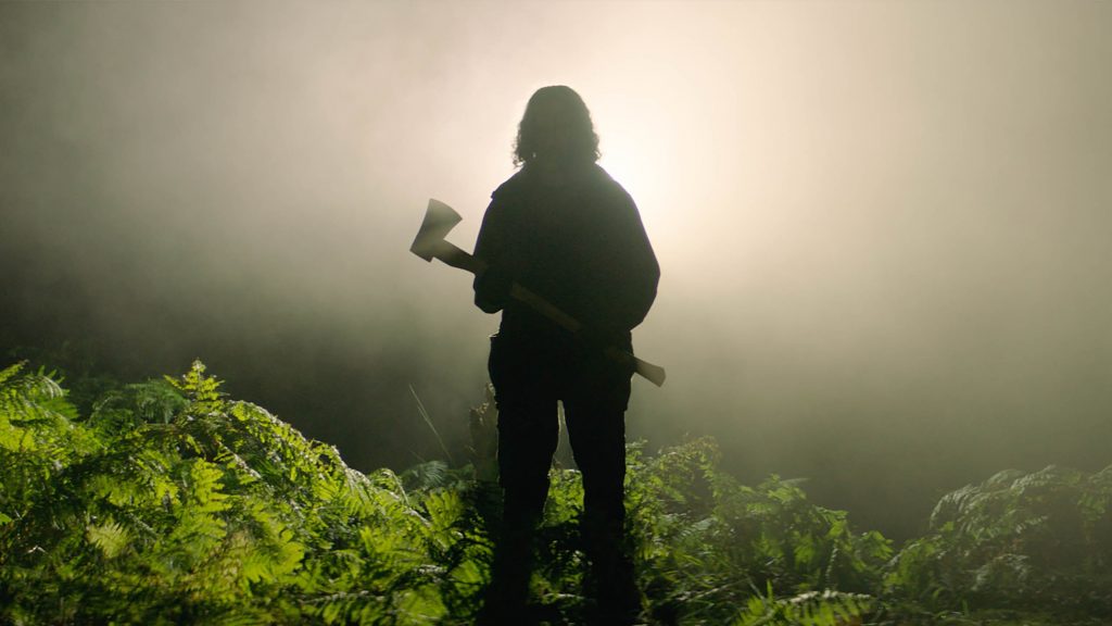 The silhoutte of a man holding an axe in the foggy forest as seen in the Sundance 2021 selection In the Earth, directed by Ben Wheatley.