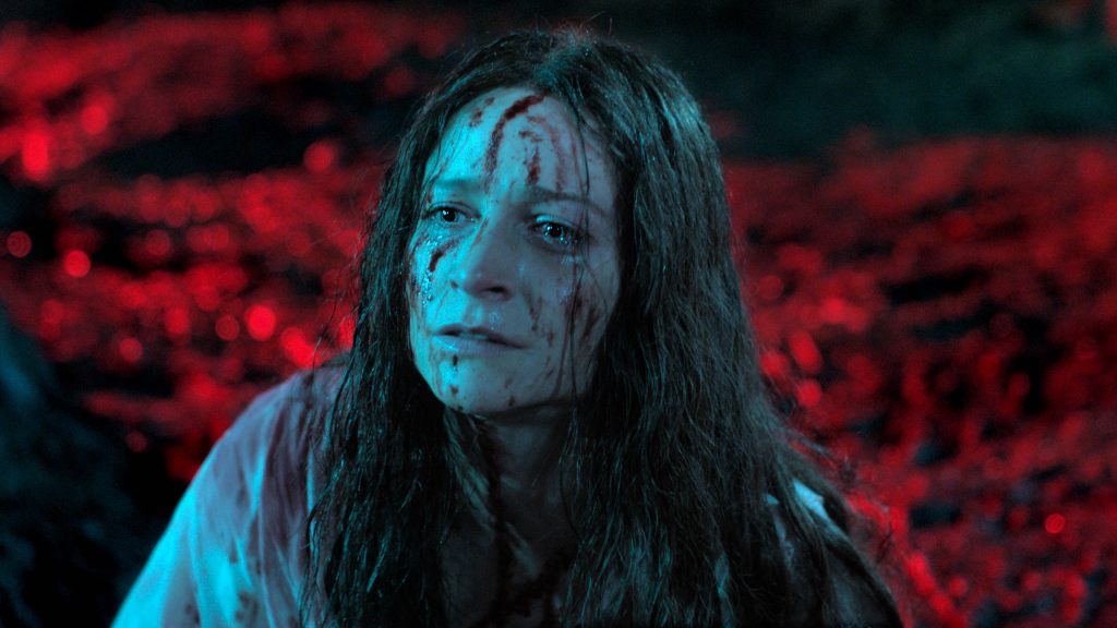 Niamh Algar in a bloody, dirty white gown as seen in Sundance 2021 horror film Censor.