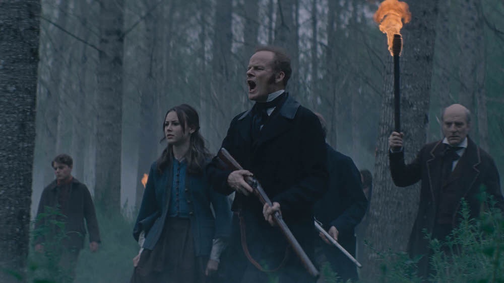 Alistair Petrie, Amelia Crouch, and Simon Kunz lead a search party in a gothic forest as seen in Eight for Silver directed by Sean Ellis.