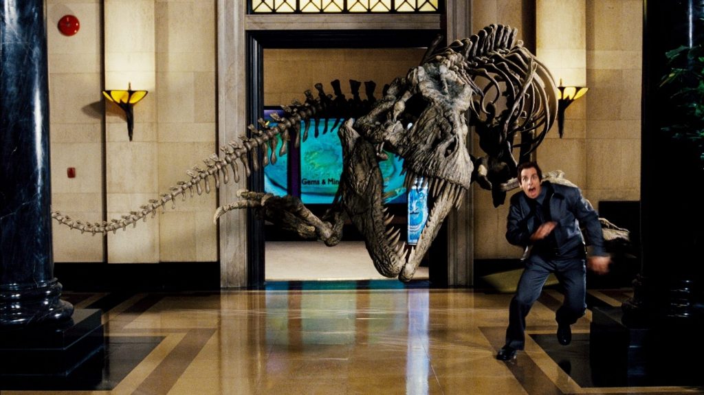 Ben Stiller as Larry Daley running away from Rexy the Tyrannosaur fossil skeleton in Night at the Museum. 