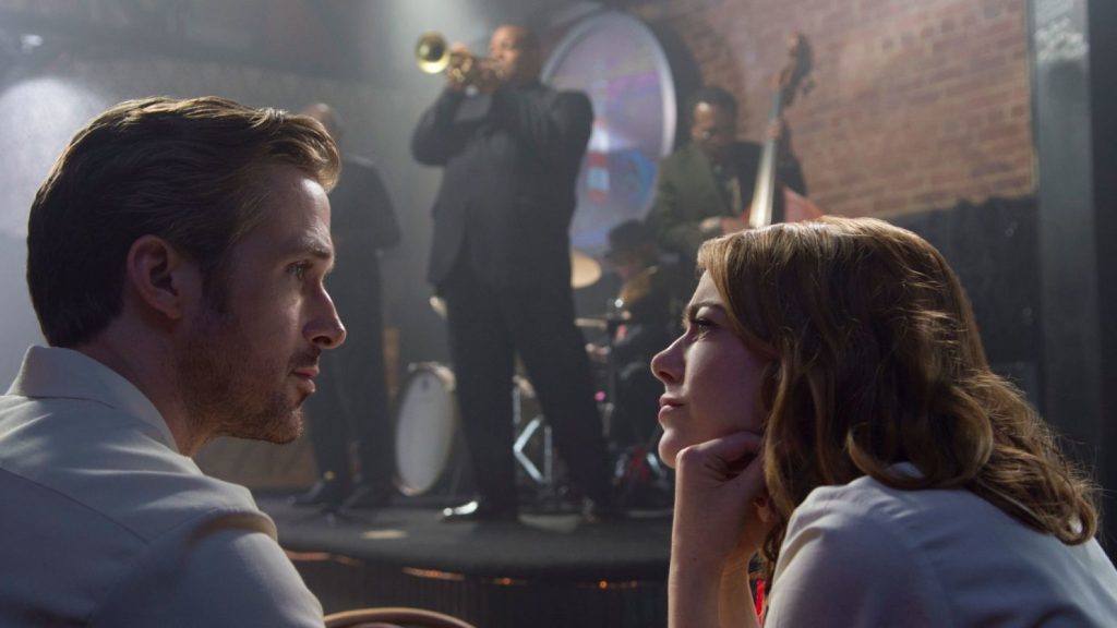 Emma Stone's Mia listening to Ryan Gosling as Seb in a jazz club in La La Land.