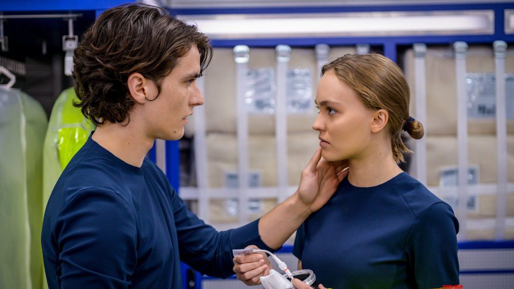Fionn Whitehead holding Lily-Rose Depp's face in a futuristic space ship as seen in Voyagers. 