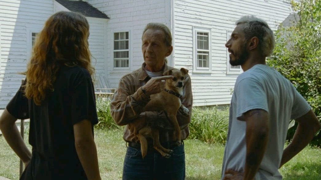 Olivia Cooke, Paul Raci holding a small dog, and Riz Ahmed standing together as seen in the 6 time Oscar-nominated film Sound of Metal.