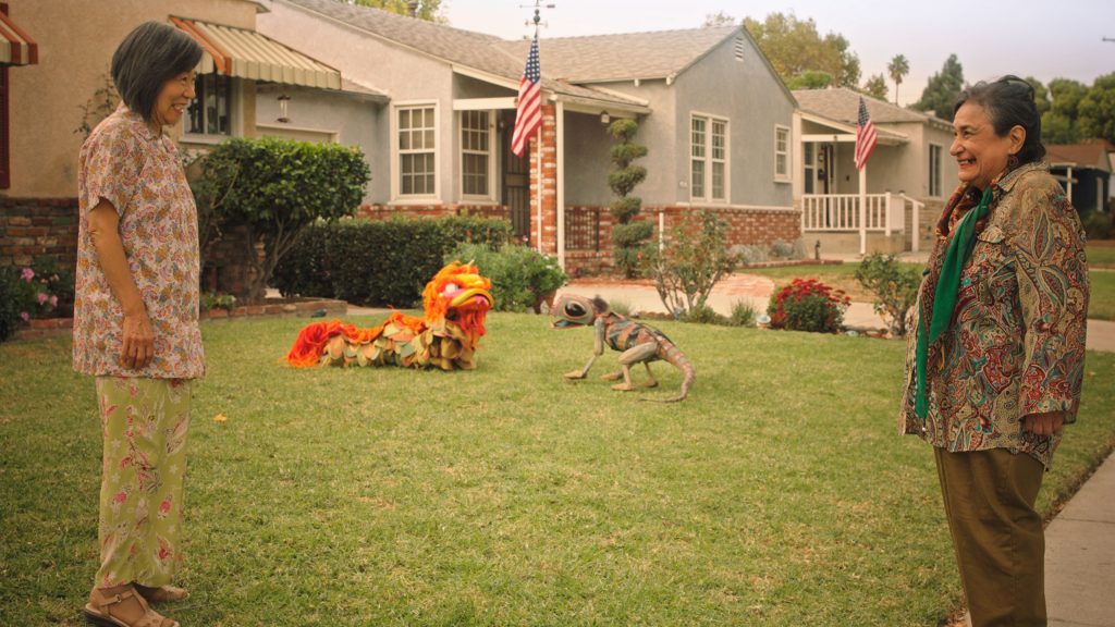 Two elderly people meet while chupacabra and dragon decorations are seen on the front lawn as seen in the short The Last of the Chupacabras part of Disney's Launchpad series.