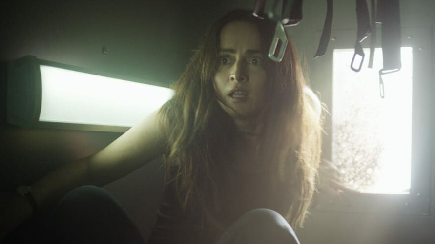 Ana de la Reguera stuck inside an upside police van as seen in the fifth and final Purge sequel from Blumhouse, THE FOREVER PURGE.