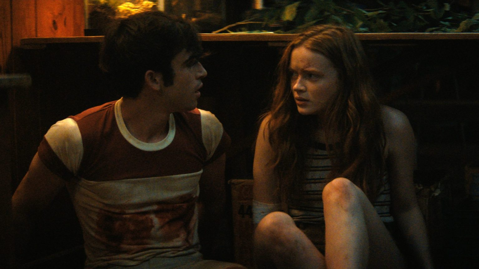 Ted Sutherland and Sadie Sink hiding together from a mysterious killer as seen in the Netflix original Horror movie FEAR STREET PART TWO: 1978