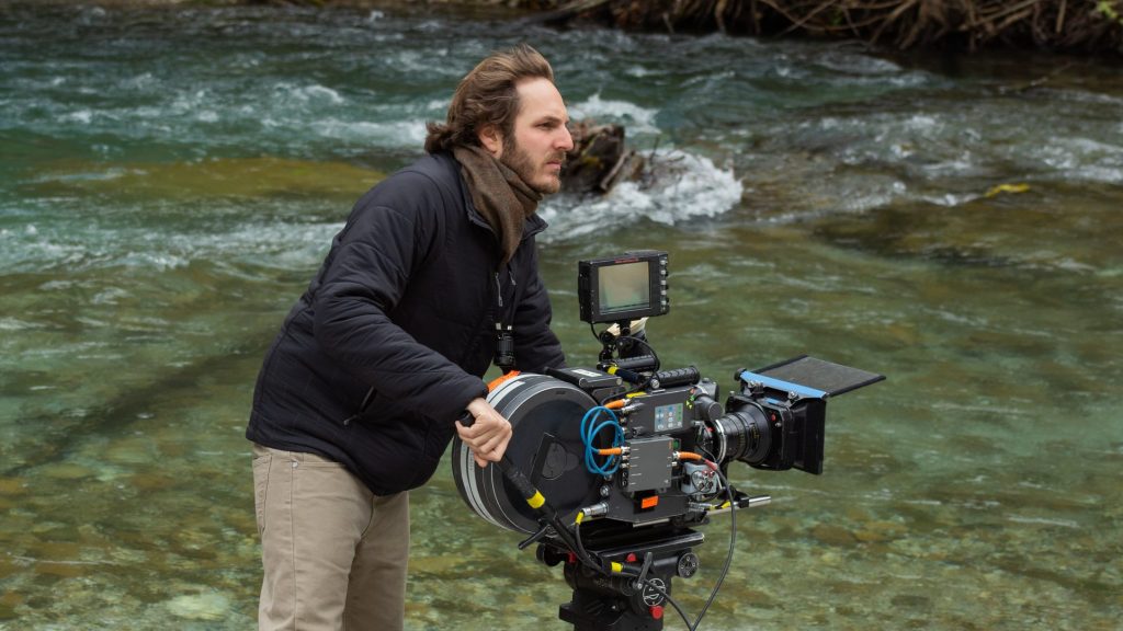 Director Ferdinando Cito Filomarino operating a camera on location in a river in Greece behind the scenes of the new Netflix thriller BECKETT. 