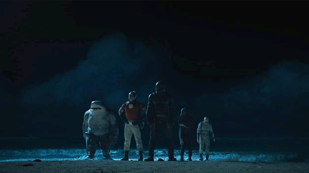 The members of Task Force X make their way onto a dark beach from the ocean waters as seen in THE SUICIDE SQUAD directed by James Gunn, taking the very top spot in our DCEU ranking from worst to best. 