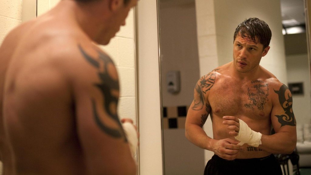 Tom Hardy looks at himself in the mirror as he prepares for an MMA fight as seen in WARRIOR directed by Gavin O'Connor, now celebrating its 10 year anniversary. 