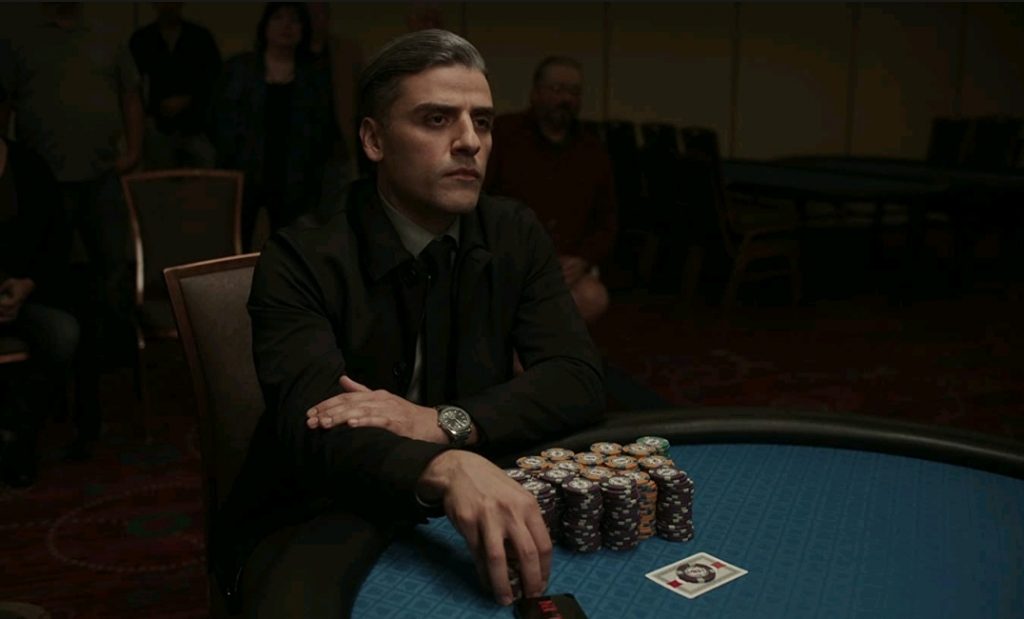 Oscar Isaac playing competitive poker with a straight blank face as seen in THE CARD COUNTER directed by Paul Schrader.