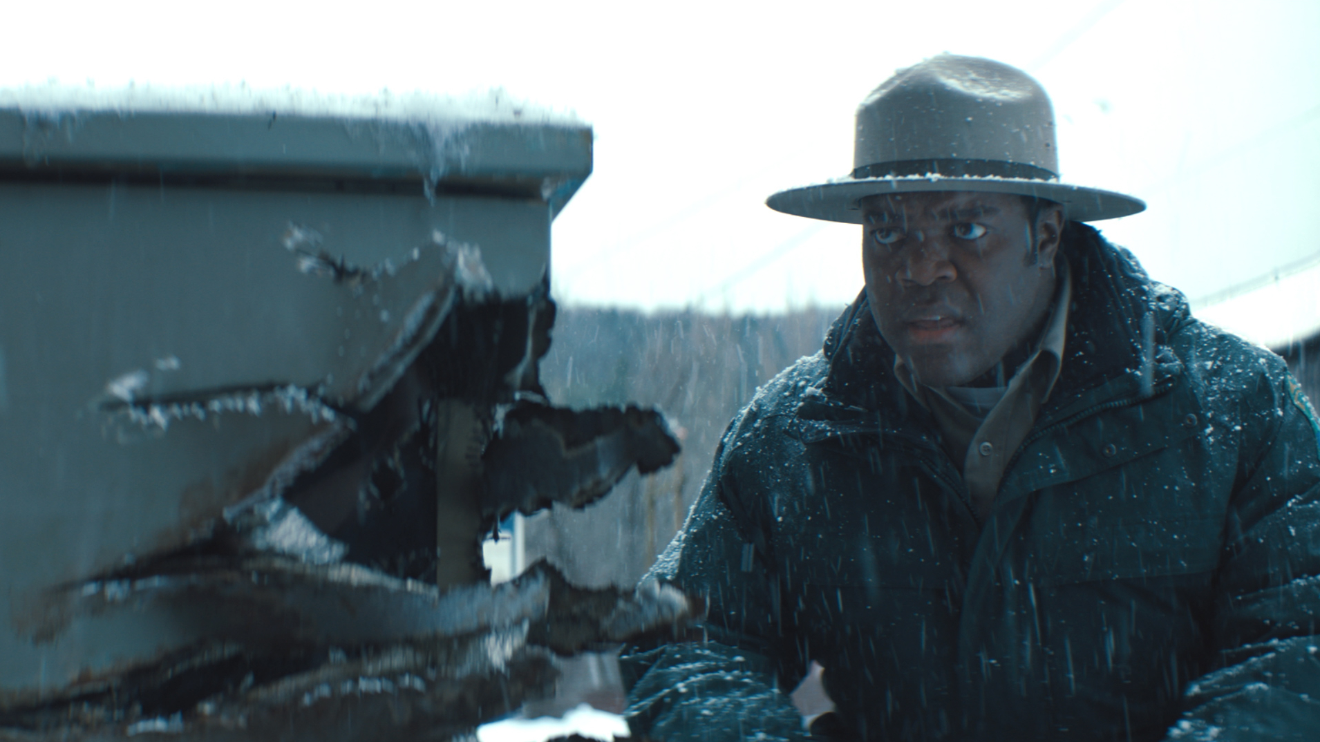 Sam Richardson as forest ranger Finn Wheeler inspects a car that's been damaged by a werewolf as seen in WEREWOLVES WITHIN - one of our top 10 best horror films of the year so far.  
