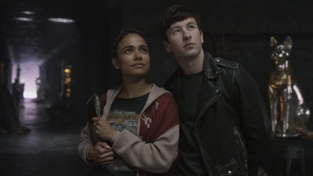 Lauren Ridloff as Makkari and Barry Keoghan as Druig stand closely together on a space ship in front of some ancient artifacts as seen in the new Marvel Studios film ETERNALS.
