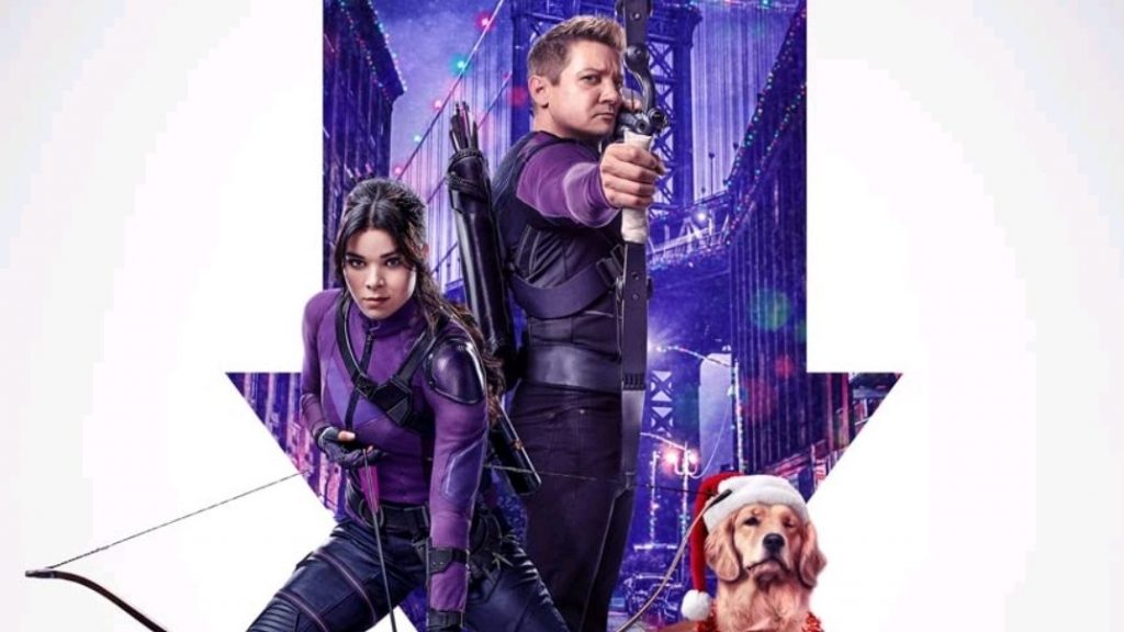 Hailee Steinfeld and Jeremy Renner pose with their bows and arrows next to Lucky the Golden Retriever wearing a Santa hat on the official poster for the new Marvel series HAWKEYE coming to Disney+ November 2021.