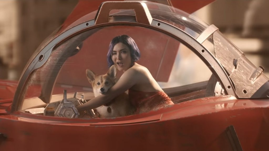 Daniella Pineda as Faye Valentine winks at the camera as she flies away in her red spaceship with Ein the Corgi on her lap as seen in the live-action adaptation of COWBOY BEBOP on Netflix, coming November 2021.