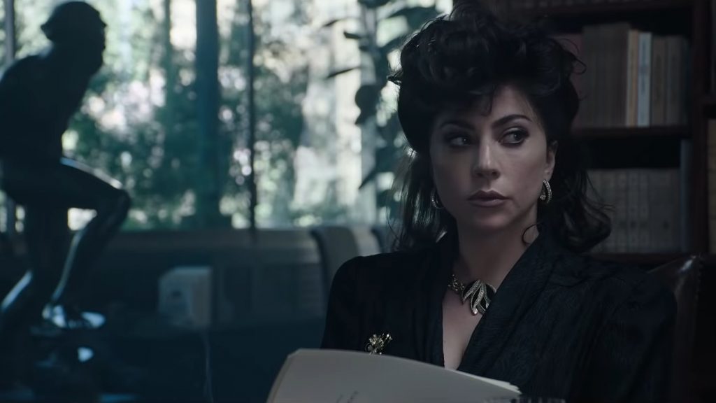 Lady Gaga as Patrizia Reggiani wearing all black looking over the Gucci family will as seen in HOUSE OF GUCCI directed by Ridley Scott.
