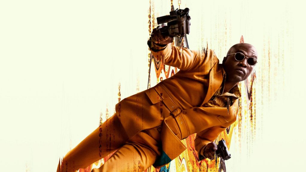 Yahya Abdul-Mateen II wears a dark gold suit with circular shades as the new young Morpheus while shooting two mini uzi guns on his official poster for THE MATRIX RESURRECTIONS, coming to HBO Max in December 2021.