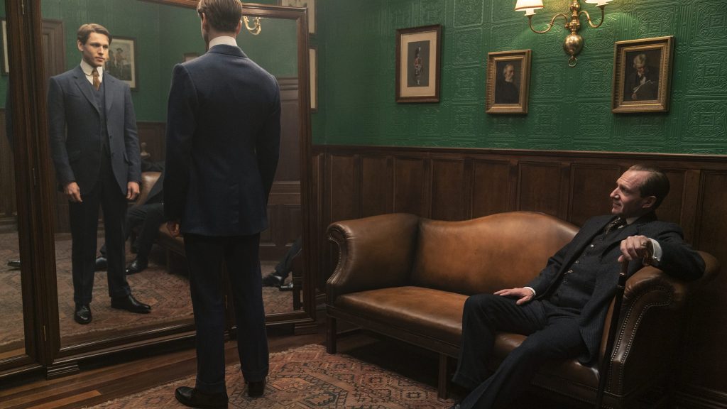 Harris Dickinson as Conrad and Ralph Fiennes as Oxford trying out new suits in the iconic Kingsman fitting room as seen in THE KING'S MAN directed by Matthew Vaughn.