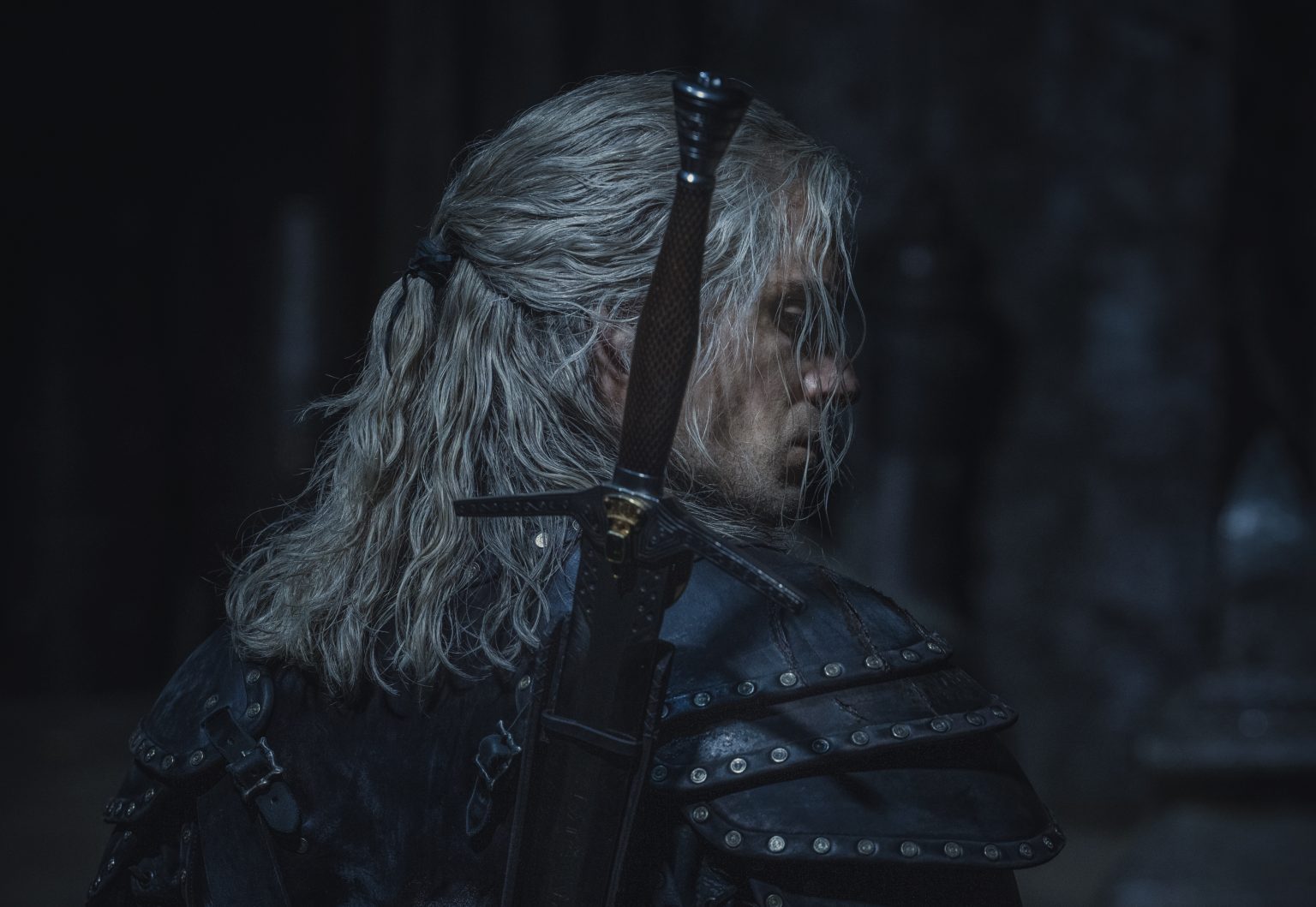 Henry Cavill as Geralt of Rivia looking over his shoulder with his sword on his back as seen in season 2 of THE WITCHER, coming to Netflix in December 2021.