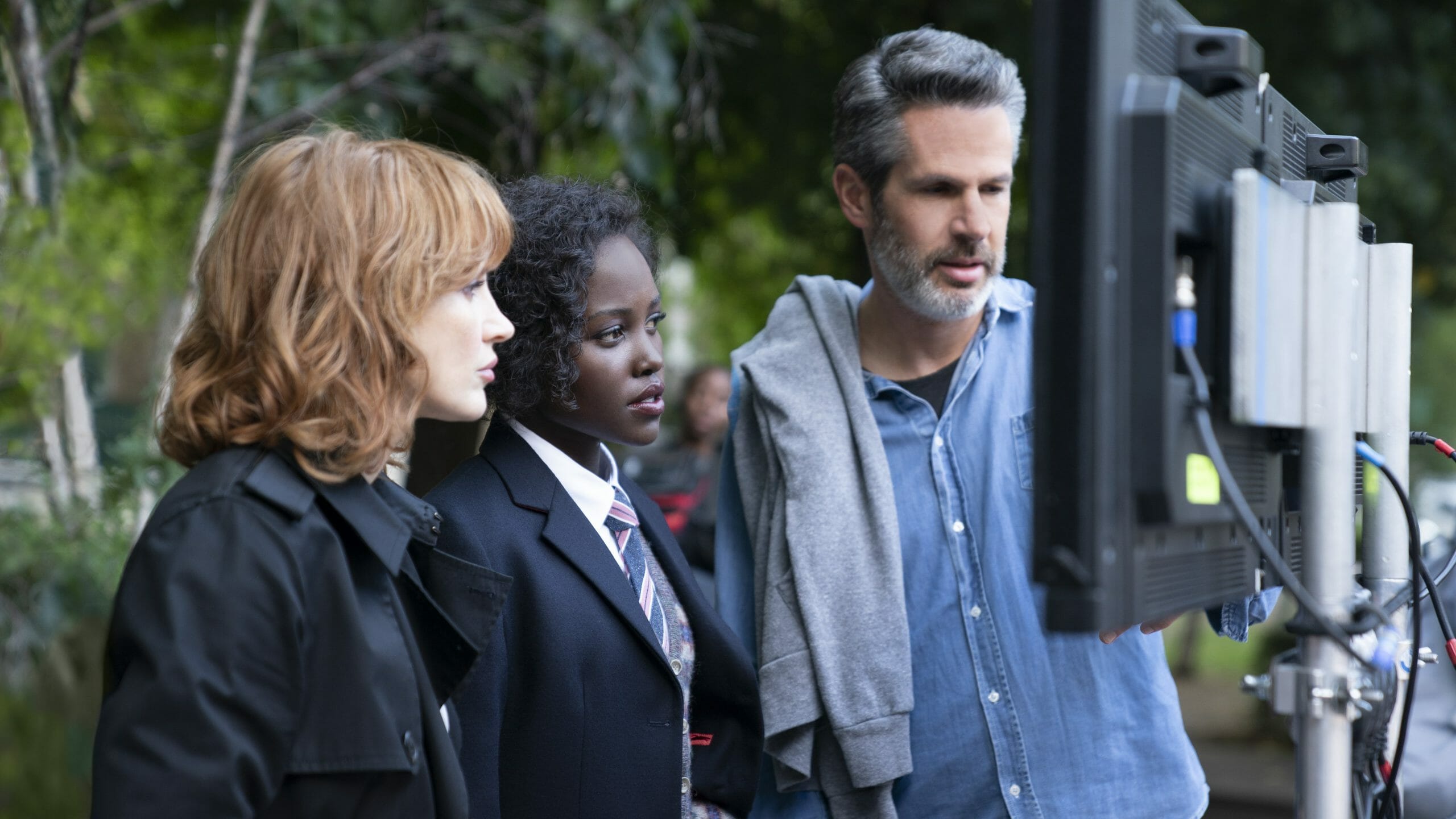 Lead actresses Jessica Chastain and Lupita Nyong'o overlook camera footage with director and writer Simon Kinberg on the set of the all-female lead spy thriller, The 355. 