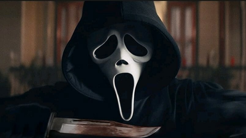 The new Ghostface killer holds a bloody, sharp blade up to the iconic white mask in the 5th entry of the SCREAM franchise.