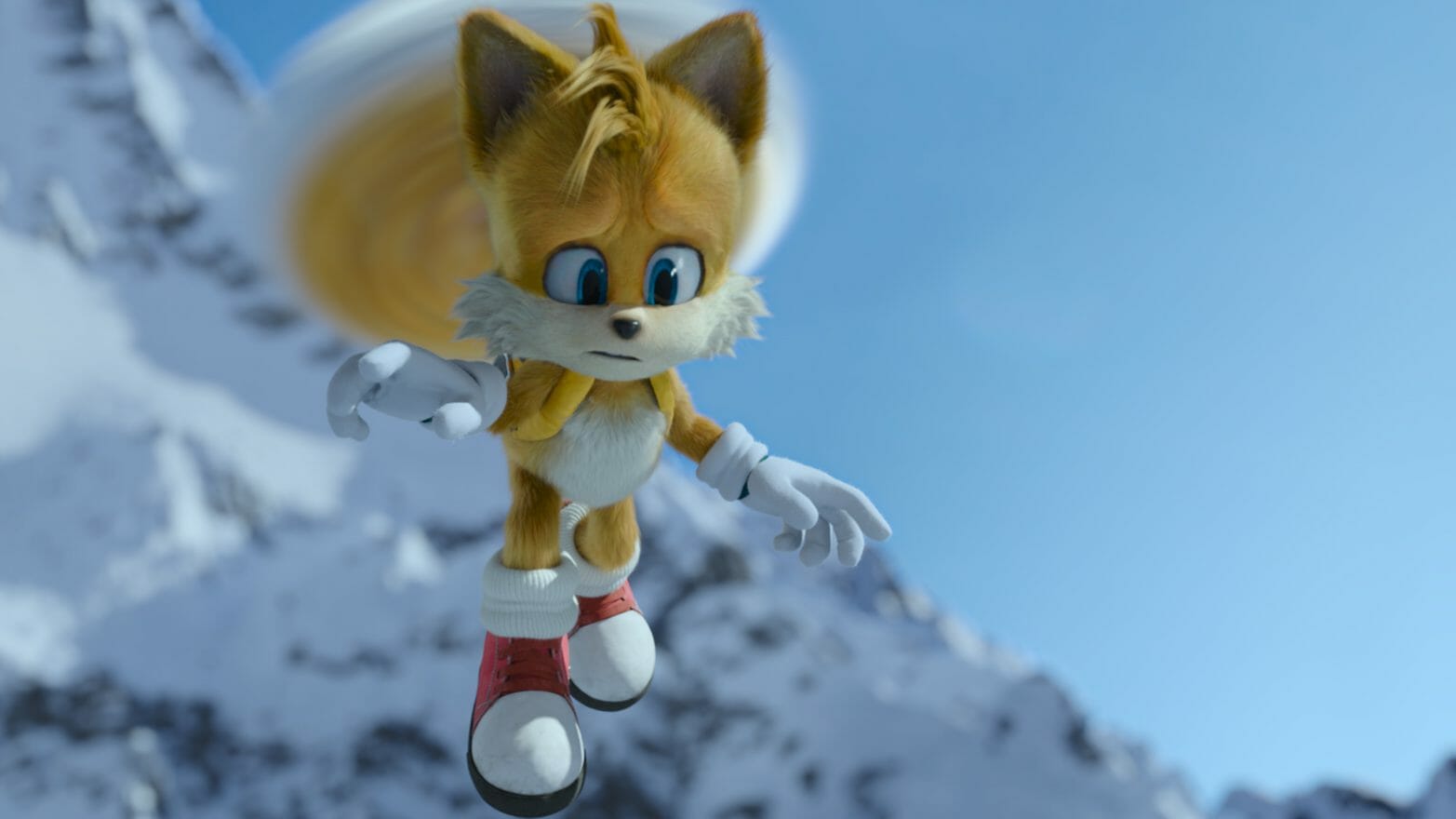 Tails flies sporting his yellow backpack in front of a snowy mountain in SONIC THE HEDGEHOG 2 directed by Jeff Fowler. 