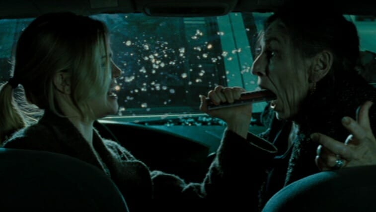 Alison Lohman shoves a blunt object down the throat of a gypsy witch from inside her car in DRAG ME TO HELL directed by Sam Raimi. 