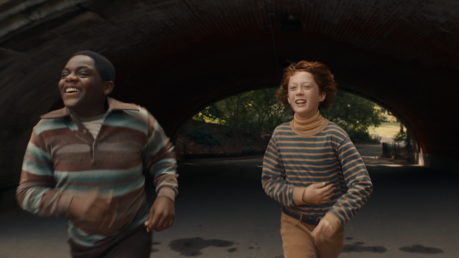Jaylin Webb and Banks Repeta run together happily through a long tunnel in a New York park in ARMAGEDDON TIME directed by James Gray.