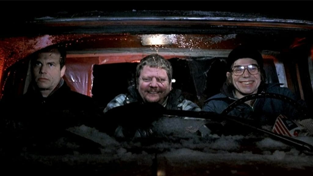 Billy Bob Thornton and Brent Biscoe ride happily in a van together in the snow as Bill Paxton sits annoyed in the passenger seat from A SIMPLE PLAN directed by Sam Raimi. 