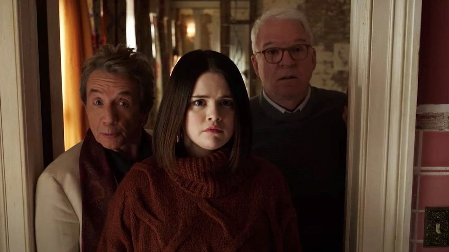 Martin Short, Selena Gomez, and Steve Martin stand together in total shock after opening a door in ONLY MURDERS IN THE BUILDING Season 2.