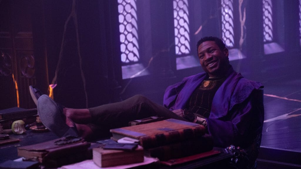 Jonathan Majors as the Kang variant He Who Remains leans back on his desk at the Citadel at the End of Time with a giant smirk on his face as seen in the Season 1 finale of LOKI.