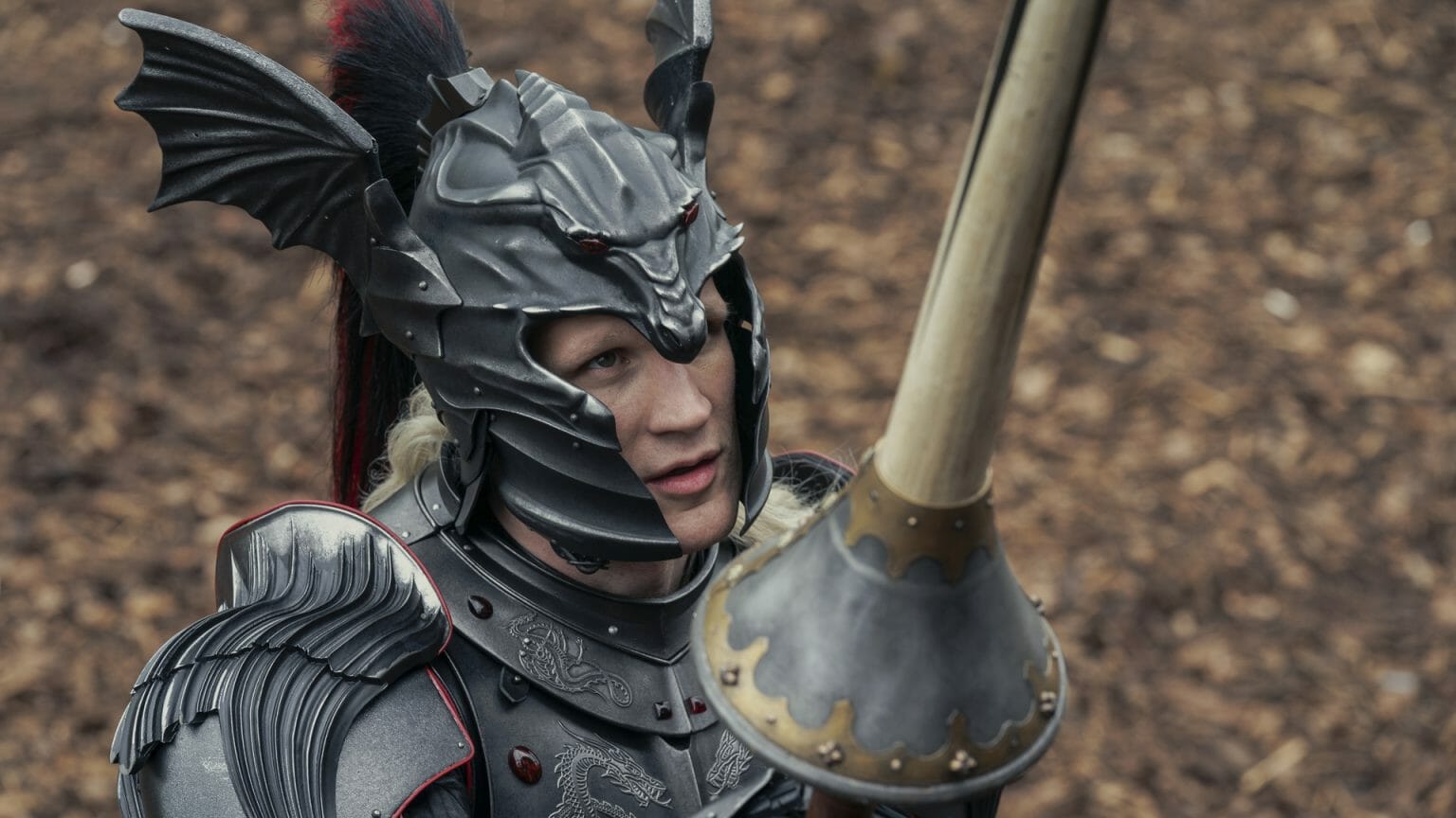 Matt Smith stars as the lucrative Prince Daemon Targaryen in his black dragon battle armor while holding a lance in HOUSE OF THE DRAGON on HBO.