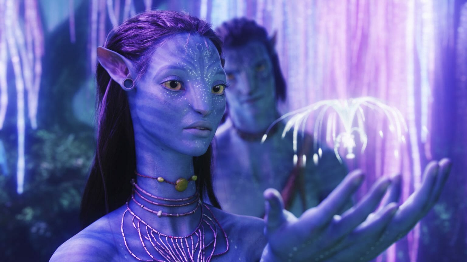 Neytiri played by Zoe Saldaña holds a woodspite Eywa seed from the tree of souls in AVATAR directed by James Cameron.