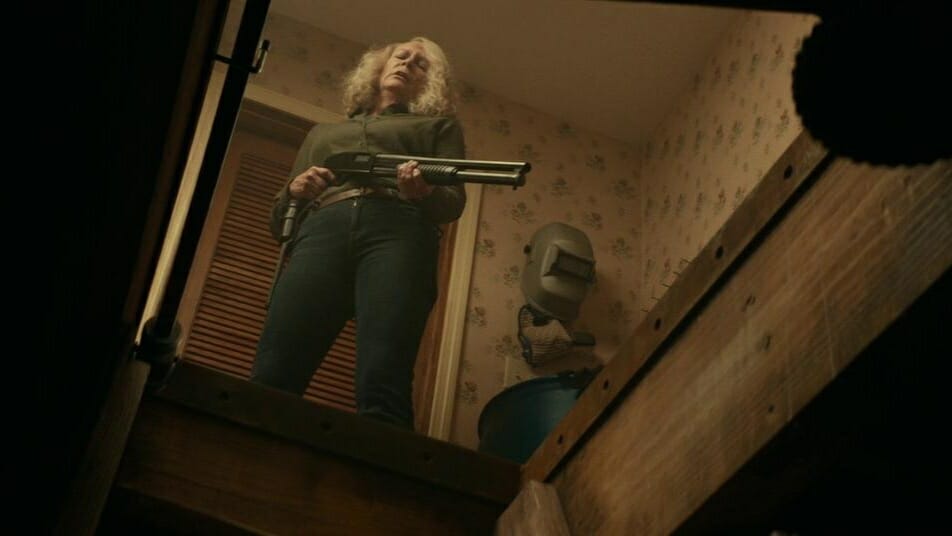 Jamie Lee Curtis holds a shotgun while looking down into her emergency basement from the 2018 David Gordon Green HALLOWEEN legacy sequel. 