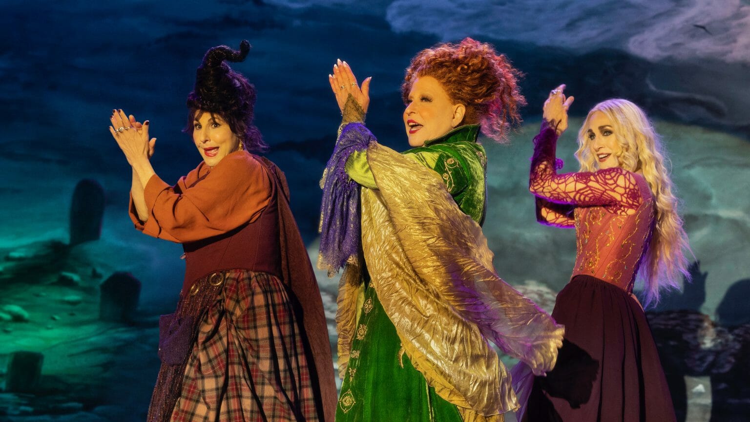 The three iconic Sanderson witch sisters played by Bette Midler, Sarah Jessica Parker, and Kathy Najimy perform a musical number of One Way or Another by Blondie on stage in HOCUS POCUS 2 streaming only on Disney+.