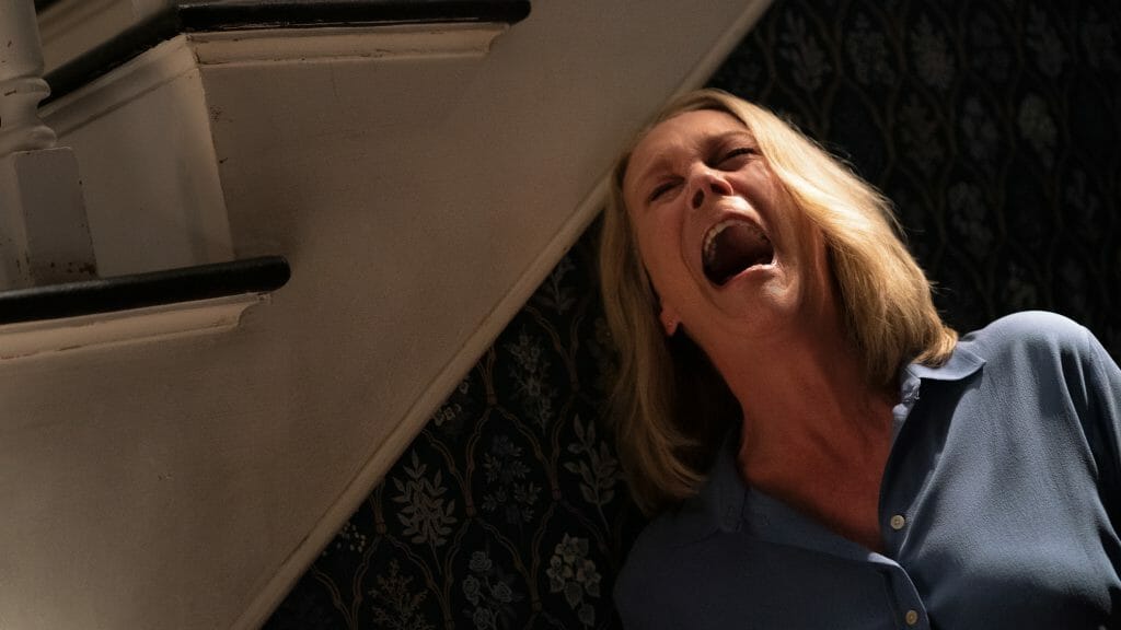 Jamie Lee Curtis as Laurie Strode shrieks in terror as she's being chased by Michael Myers in her home for the last time in HALLOWEEN ENDS. 