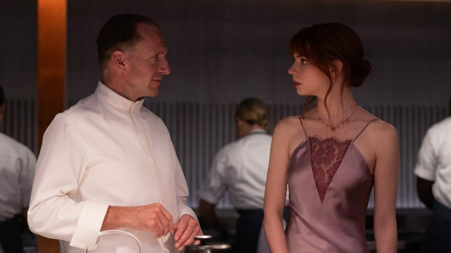Anya Taylor-Joy as Margot and Ralph Fiennes as Chef Slowik come face to face in the Hawthorne restaurant kitchen from dark comedy horror satire film THE MENU.