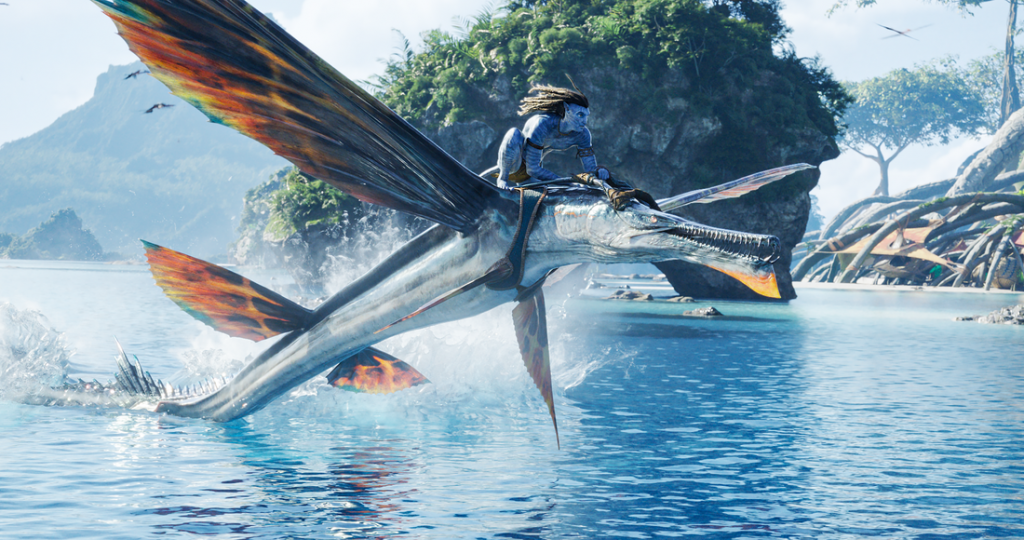 Jake Sulley rides a giant flying fish alien creature called a Skimwing into battle holding a machine gun in AVATAR: THE WAY OF WATER.
