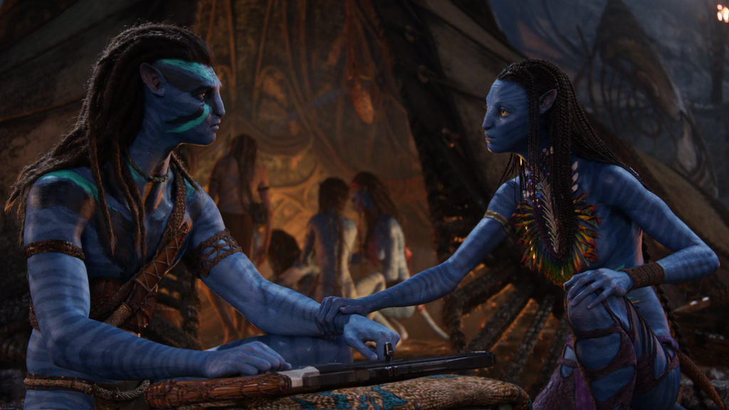 Jake Sulley played by Sam Worthington and Neytiri played by Zoe Saldaña share a private moment while their children play in the background of their new clan in AVATAR: THE WAY OF WATER.