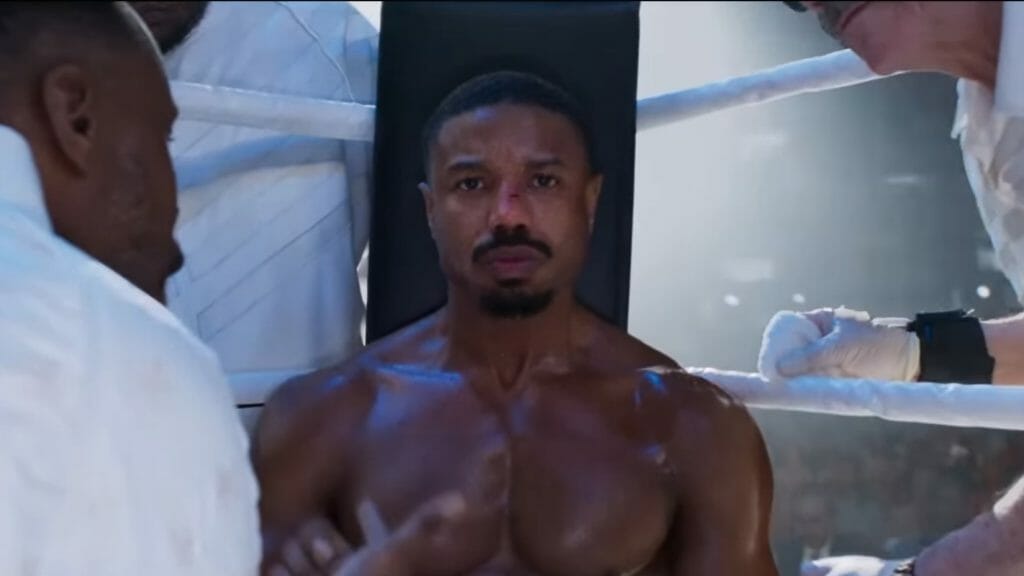 Michael B. Jordan as Adonis Creed sits beaten in his corner during the epic final boxing match of CREED III.