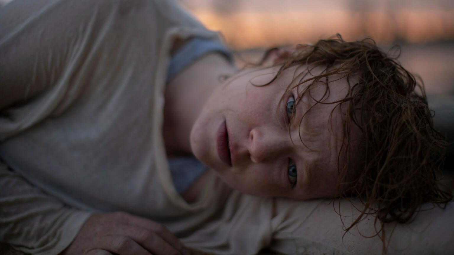 Sarah Snook lies defeated on the floor with a pale face and crazy hair in the psychological horror film from Australia RUN RABBIT RUN.