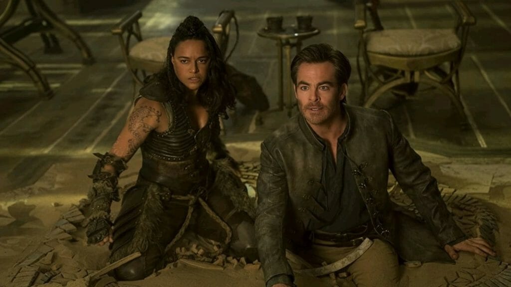 Chris Pine as the Bard Edgin Darvis and Michelle Rodriguez as the barbarian warrior Holga Kilgore get trapped in magical quick sand in the movie DUNGEONS & DRAGONS: HONOR AMONG THIEVES.