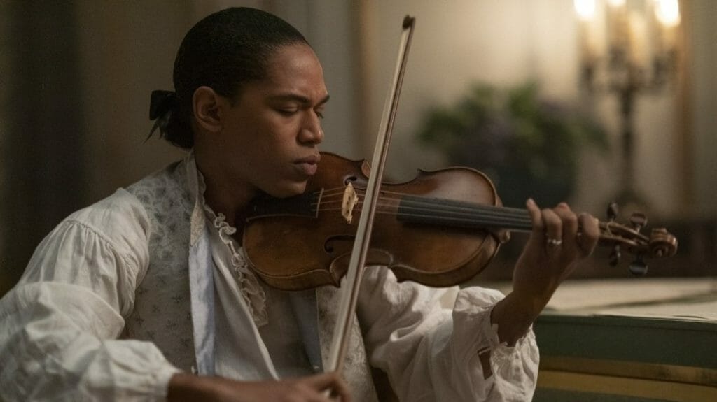 Kelvin Harrison Jr. stars as the French composer Joseph Bologne, Chevalier de Saint-Georges, practicing his violin with passion in his private quarters in the period biopic film CHEVALIER.