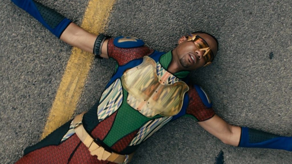 The superhero A-Train suffers from a heart attack on the pavement of a road in THE BOYS Season 3 on Prime Video. 